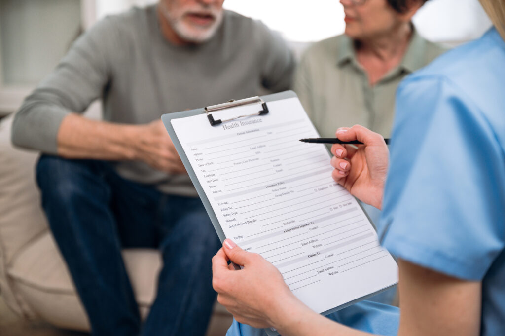 Couple on couch with a clincial researcher holding a clipboard to register them.