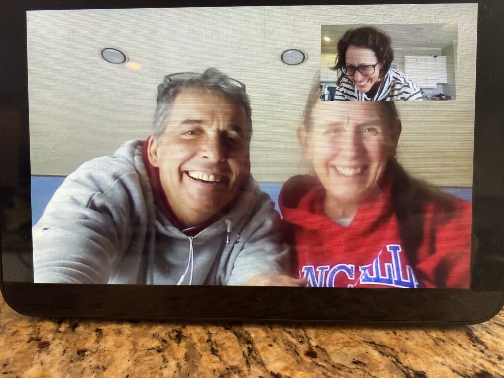 Two adults smiling on a tablet video call with a remote family member, representing trust and connection in healthcare data sharing.